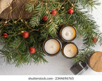 Soy candles burn in glass jars. Comfort at home. Candle in a brown jar. Scent and light. Scented handmade candle. Aroma therapy. Christmas tree and winter mood. Cozy decor. Festive garland decoration - Shutterstock ID 2344696765