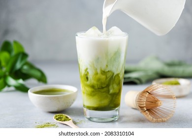Soy milk pouring in matcha ice tea. Healthy vegan drink