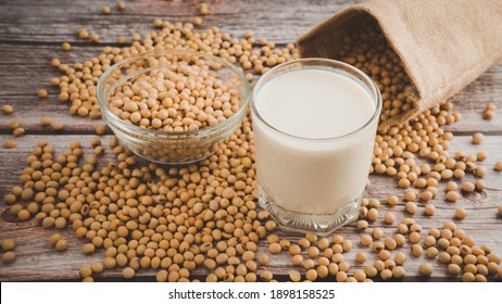 Soy milk and Soybeans in glass bowl on wooden table background.Healthy food Concept.