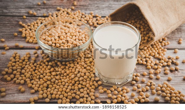 Soy milk and Soybeans in glass bowl on\
wooden table background.Healthy food\
Concept.