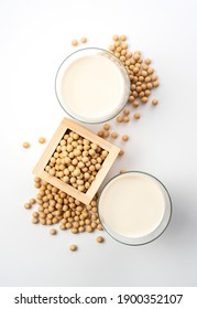 Soy milk and soybeans in a glass placed on a white background. View from directly above