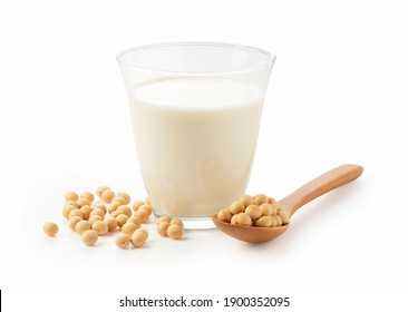 Soy milk and soybeans in a glass with a wooden spoon on a white background
