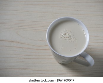 Soy milk in a white cup on the table - Shutterstock ID 1964909047