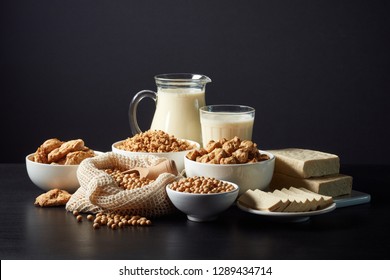 Soy products: soy beans, soy milk, tofu and soya chunks on black background