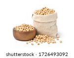 Soybeans seeds in wooden bowl and fabric hemp bag isolated on white background.
