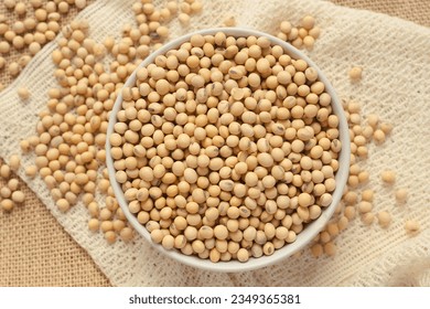 Soybeans. Soybean seeds in ceramic bowl on sackcloth, super food, vegetarian, top view, close-up.