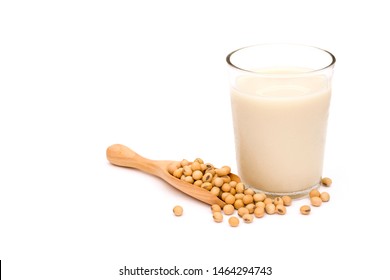 Soybeans in wooden scoop and glass of soy milk isolated on white background. Healthy drinks concept.