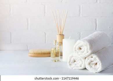SPA aromatherapy background.  Still life with white towel, bath oil, massage brush and candle.