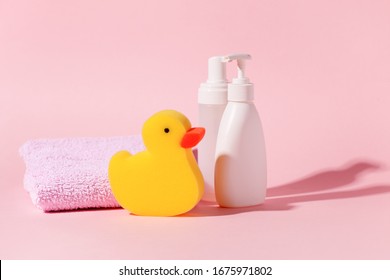 Spa And Bath Concept. Baby Bath Set. Cute Child Spa Composition In Yellow Pink Color. Soap Bottle, Multicolored Towel, Washcloth Duck. Copy Space, Minimal Trendy Idea