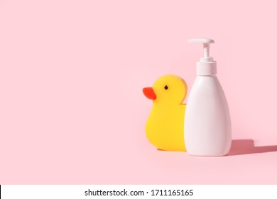 Spa and bath concept. Baby bath set. Cute child spa composition in yellow pink color. Soap bottle and washcloth duck. Copy space, minimal trendy idea, banner, flyer