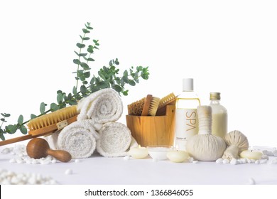 Spa Bath Setting With Eucalyptus Leaves With On Rolled Towel With Oil Bottle ,candle, Herbal Ball On Pile Of White Stones


