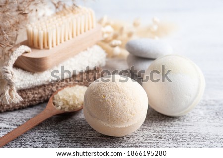 Spa composition with bath bombs and dry flowers on rustic background in monochrome style. Towel with candles and white pebbles. Hot stone massage therapy for one person. Beauty treatment and relax 