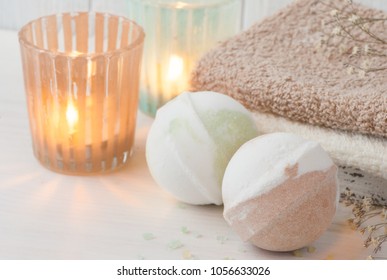SPA composition with bath bombs, lit candles. Wooden background 