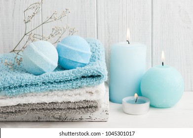 SPA composition with blue bath bombs, candles. Wooden background 