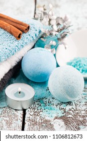 SPA composition with blue bath bombs, candle. Wooden background 