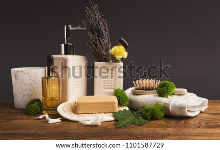 Spa composition of bottles with spa essential, aromatic oils, perfumes and flowers. Aromatherapy at gray background, side view, copy space