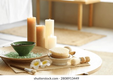 Spa composition with mud and massage brush on table in salon, closeup