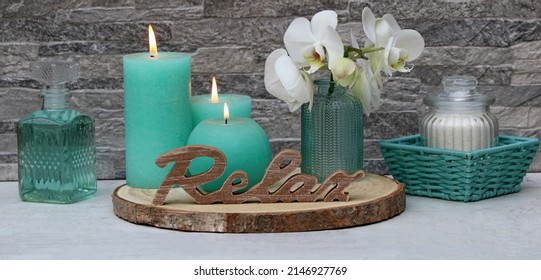 Spa composition: Relax lettering with spa products, candles, towels and orchids.