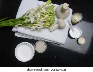 spa concept with bunch of tuberose flowers ,buds on towel, candle,cream in bowl and herbal, ball,


