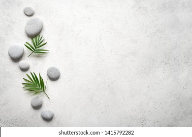 Spa concept on white stone background, palm leaves and zen like grey stones, top view, copy space.  - Shutterstock ID 1415792282