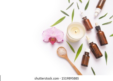 Spa concept with pink orchids ,massage salt in spoon and bottles of essential oil with small leaves, 
,candle

 - Shutterstock ID 1519895885