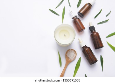 Spa concept with, massage salt in spoon and bottles of essential oil with small leave, candle - Shutterstock ID 1355691533