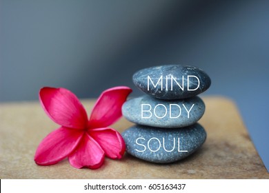 Spa concept of zen stones with deep red plumeria flower. Word Mind body soul. - Shutterstock ID 605163437