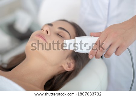 Spa. Dark-haired woman having beauty treatment in the salon and feeling relaxed