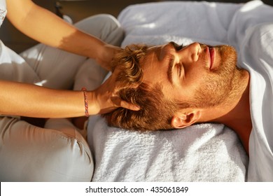 Spa Massage. Closeup Of Beautiful Healthy Happy Man Enjoying Relaxing Head Massage At Outdoor Day Salon. Masseur Hands Massaging Handsome Male Head. Relax Beauty Treatment For Men, Health Care Concept