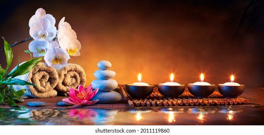 Spa Massage Stones With Candles And Towels On Bamboo Mat - Meditation Concept