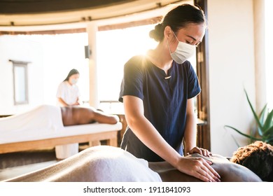 Spa Massage Therapist With Face Mask Working In The New Normal