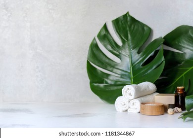 Spa And Massage Treatments On White, Marble Background Monstera Leaves. Flat Lay. Top View