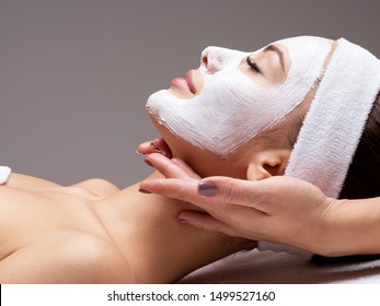 Spa Massage For Young Woman With Facial Mask On Face