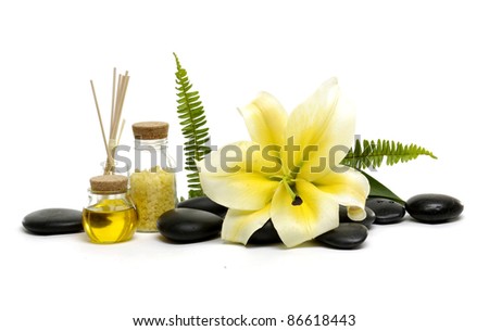 spa objects and flower madona lily and spa stones with bottle of essential oil