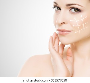 Spa portrait of a young and healthy woman with arrows on her face. Plastic surgery concept.