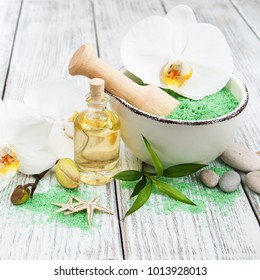 Spa products and white orchids on a old wooden table