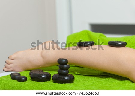 Spa relaxation, healthy pleasure concept. Woman legs and feet, hot rocks or stones massage