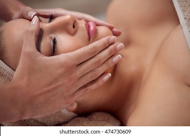 spa, resort, beauty and health concept - beautiful woman in spa salon getting face treatment