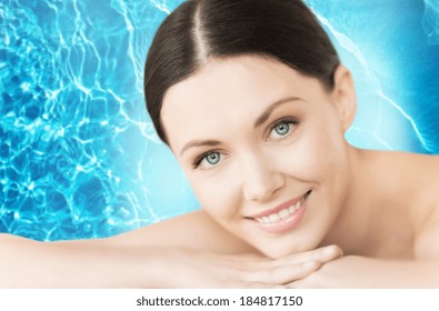 spa, resort and vacation concept - smiling woman in spa salon lying on the massage desk