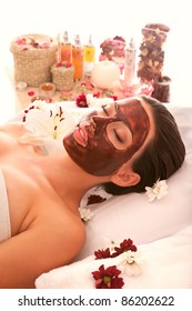 in the spa salon a beautiful girl doing a chocolate mask on your face