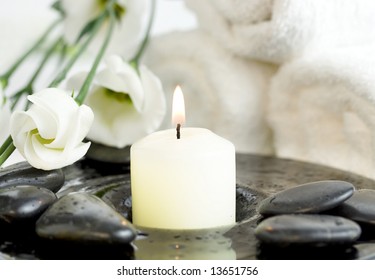 Spa setting with Beautiful white flowers, pebbles and candle. Time to relax. - Powered by Shutterstock