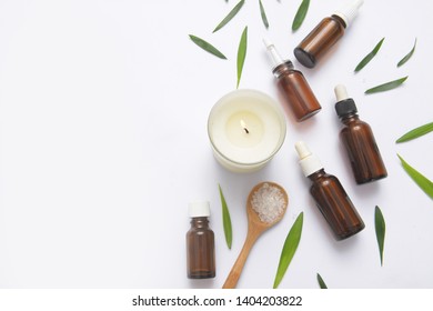Spa setting with candle and bottles of essential oil with small leave, salt in spoon  with copy space
 - Shutterstock ID 1404203822