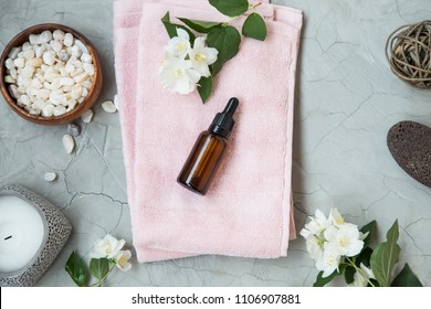 Spa setting flatlay with bath salt, jasmine oil bottle and flowers, towel and natural soap. Spa and wellness still life