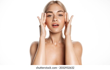 Spa and skin care. Young female model with healthy, glowing face and body, massaging using facial lotion, anti-aging cream or serum, rubbing cosmetic product with fingers, white background