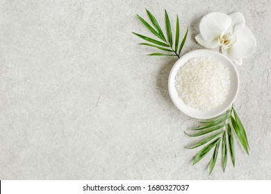 Spa Skincare Concept. Natural/Organic Spa Cosmetics Products, Sea Salt And Tropic Palm Leaves On Gray Marble Table From Above. Spa Background With A Space For A Text, Flat Lay, Top View.