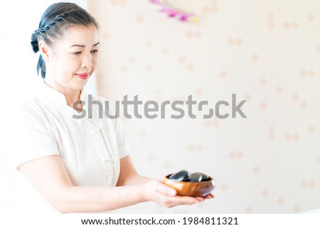 Spa staff holding hot stones for spa treatment