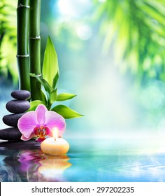 spa still life - candle and stone with bamboo in nature on water 