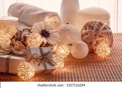 Spa still life with cosmetic creams,  towel, gift boxes and Christmas ornaments standing on bamboo mat. New Year and Christmas Healthy lifestyle, body care, Spa treatment and relaxation concept