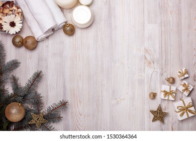 Spa still life with cosmetic creams, towel and Christmas ornaments on light wooden background. Top view with copy space. New Year and Christmas Healthy lifestyle, body care, Spa treatment