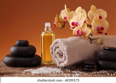 Spa still life with hot stones, essential oil and orchid